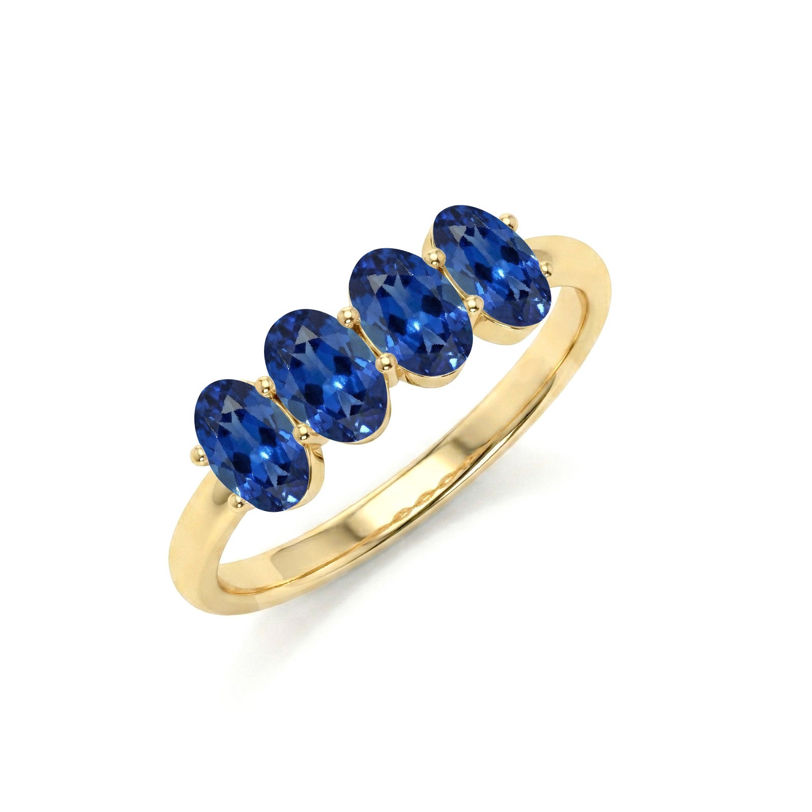 A yellow gold ring featuring four oval-cut deep blue gemstones set in a row on a polished band, shown against a plain white background.