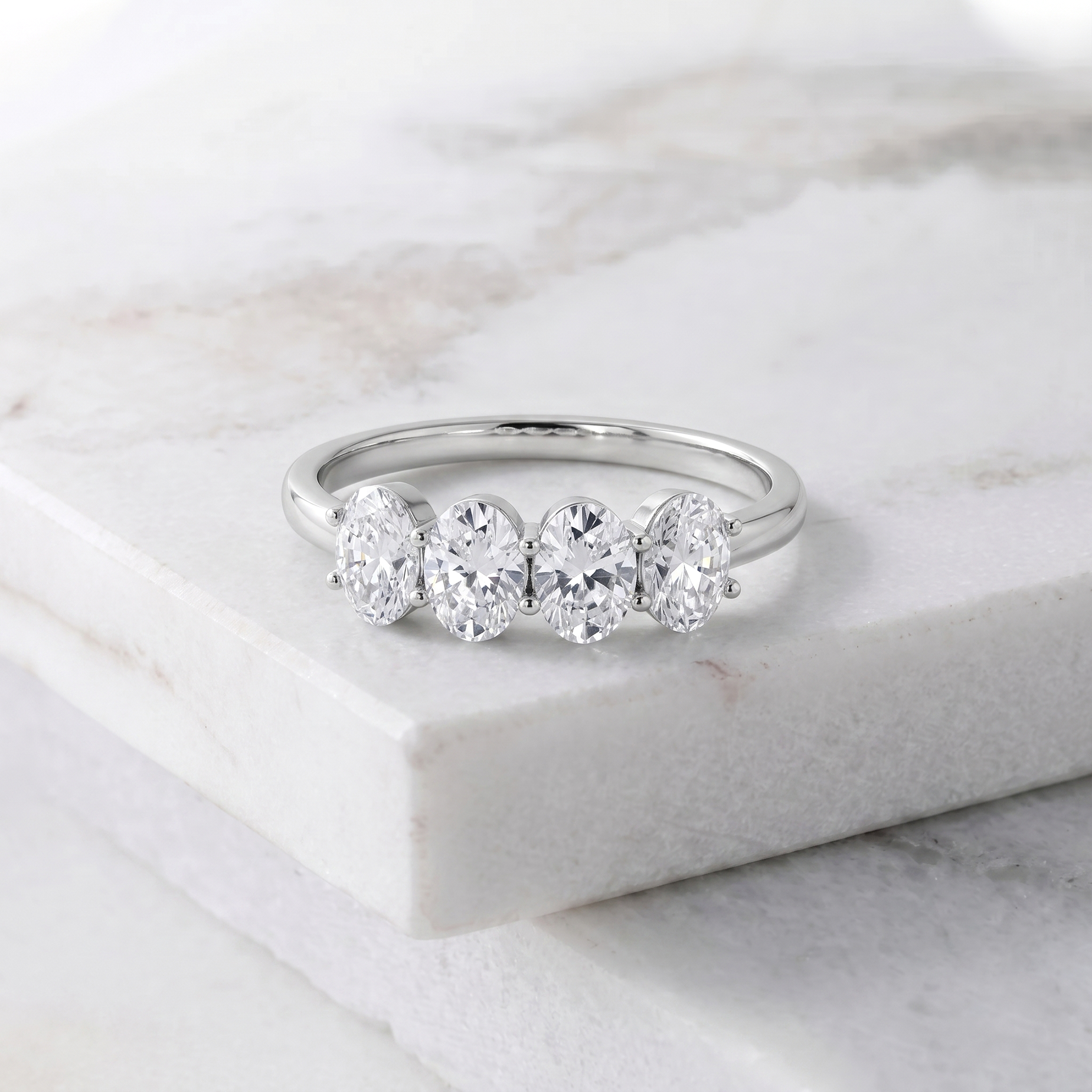 moissanite engagement ring, four gemstone band, oval cut gemstones, elegant ring design, timeless jewellery, women's ring, handcrafted jewellery, sophisticated stacking ring, bridal accessory, luxury fashion, everyday elegance, classic style