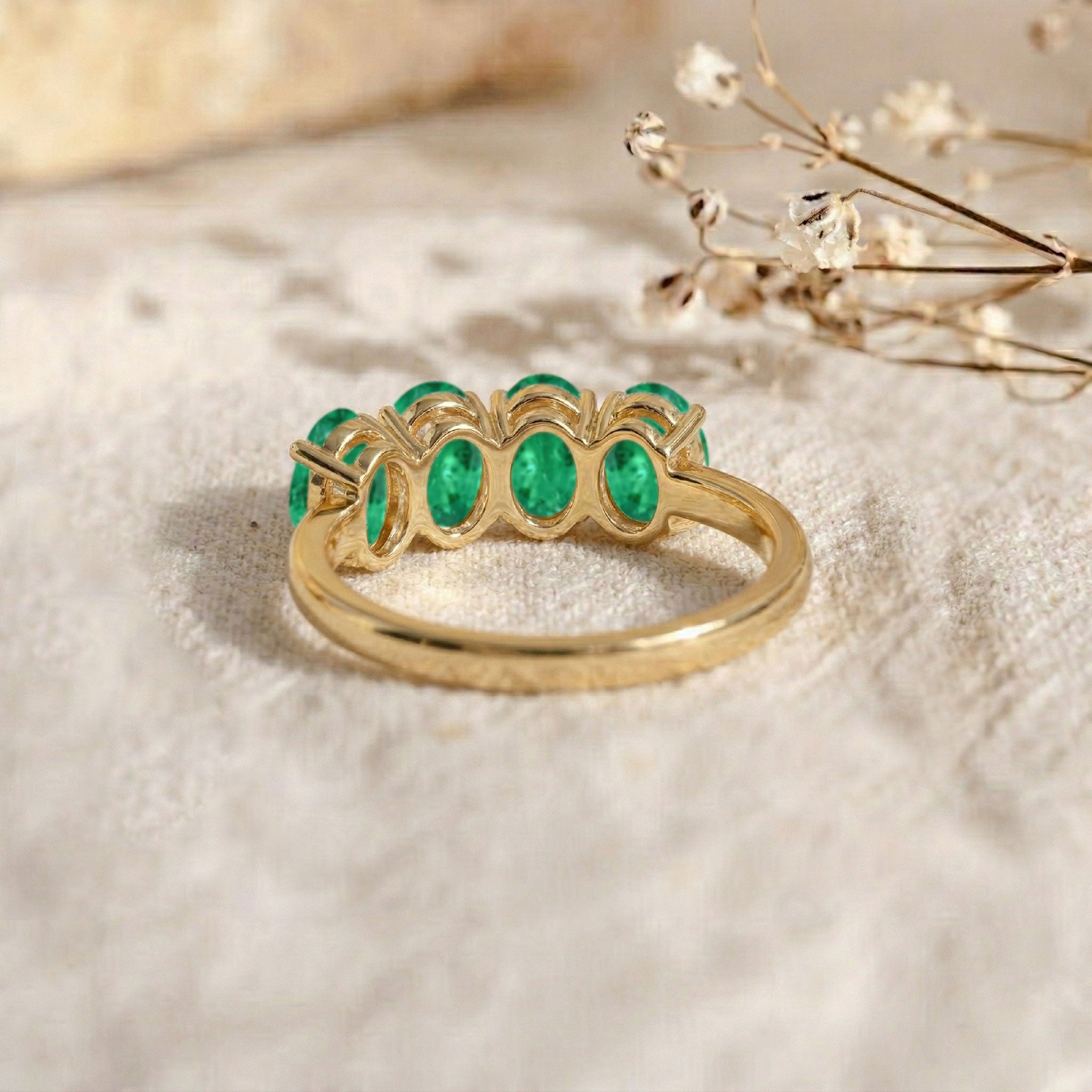 emerald anniversary ring, oval gemstone band, dainty stacking jewelry, luxury women's accessory, elegant gift idea, fine gemstone craftsmanship, contemporary bridal jewelry, vibrant emerald stones, polished silver ring, classic jewelry design, everyday ring, fashionable jewelry