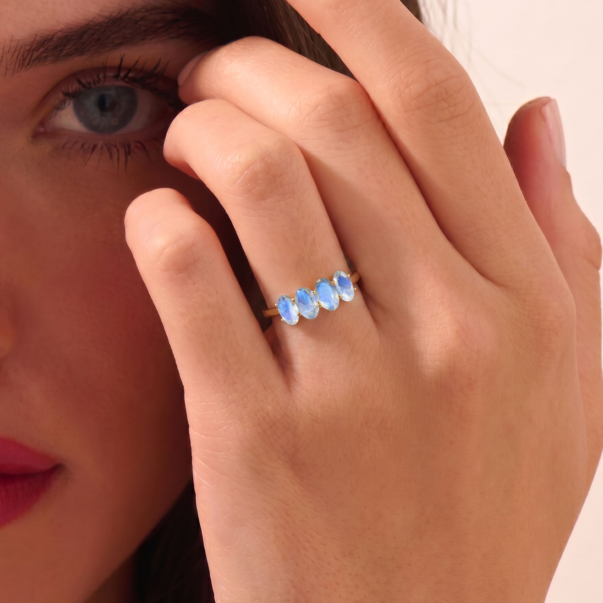 Outdoor lifestyle photograph of Genuine Moonstone Ring, natural sunlight enhancing vibrant blue flash, handcrafted sterling silver jewelry, elegant four stone moonstone ring, stackable gemstone band, June birthstone accessory, luxury artisan jewelry, premium handmade craftsmanship, delicate everyday ring, timeless gift for women inspired by nature