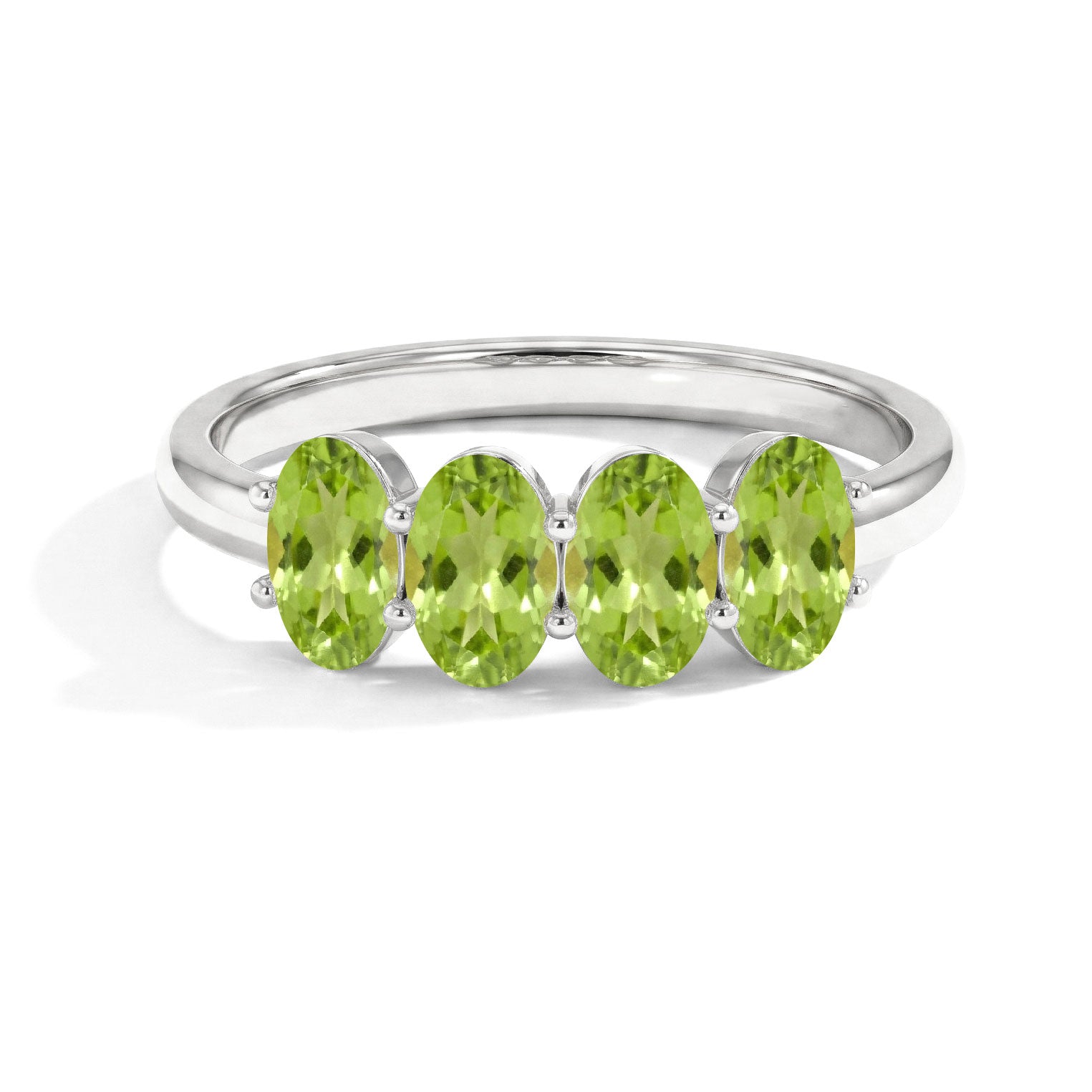 A silver ring featuring five oval-cut light green peridot gemstones in a row, set in a polished silver band on a white background.