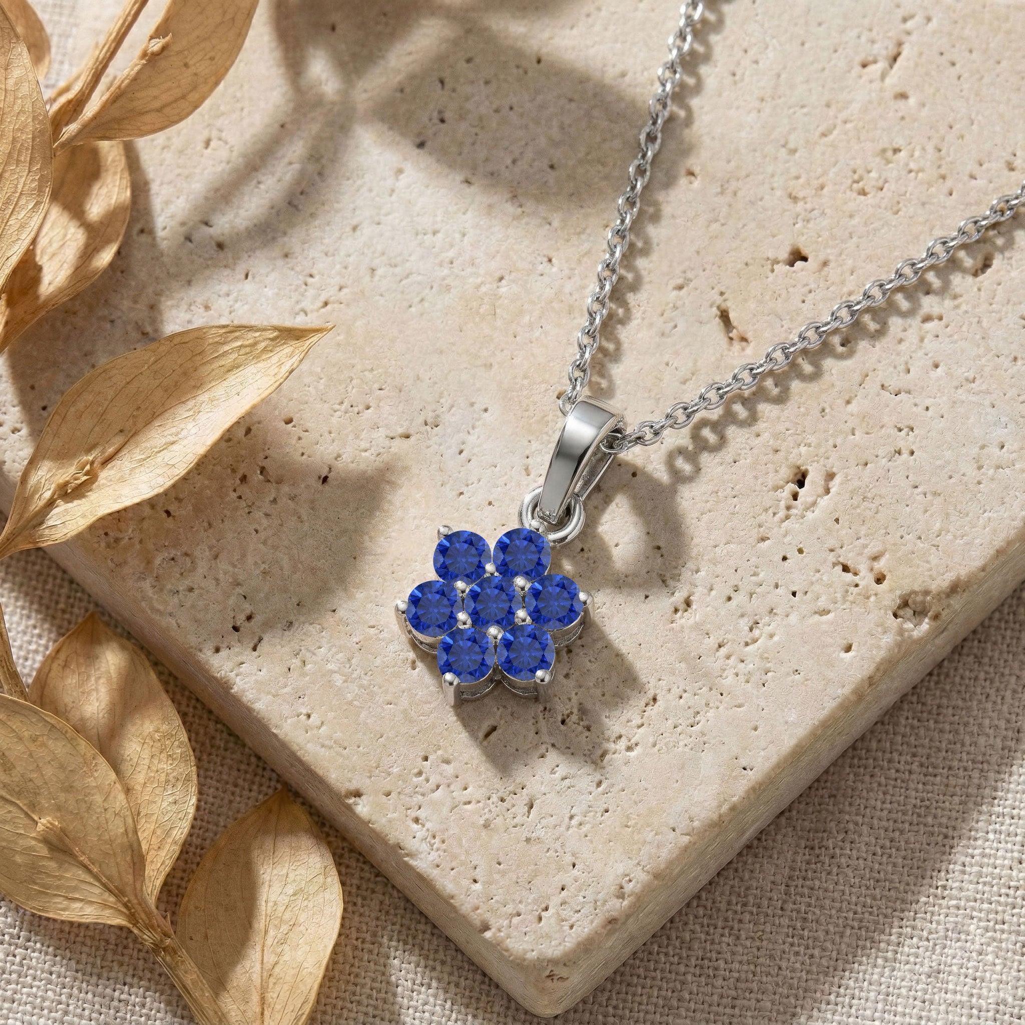 Sterling Silver Blue Sapphire pendant jewelry featuring a delicate flower inspired design.