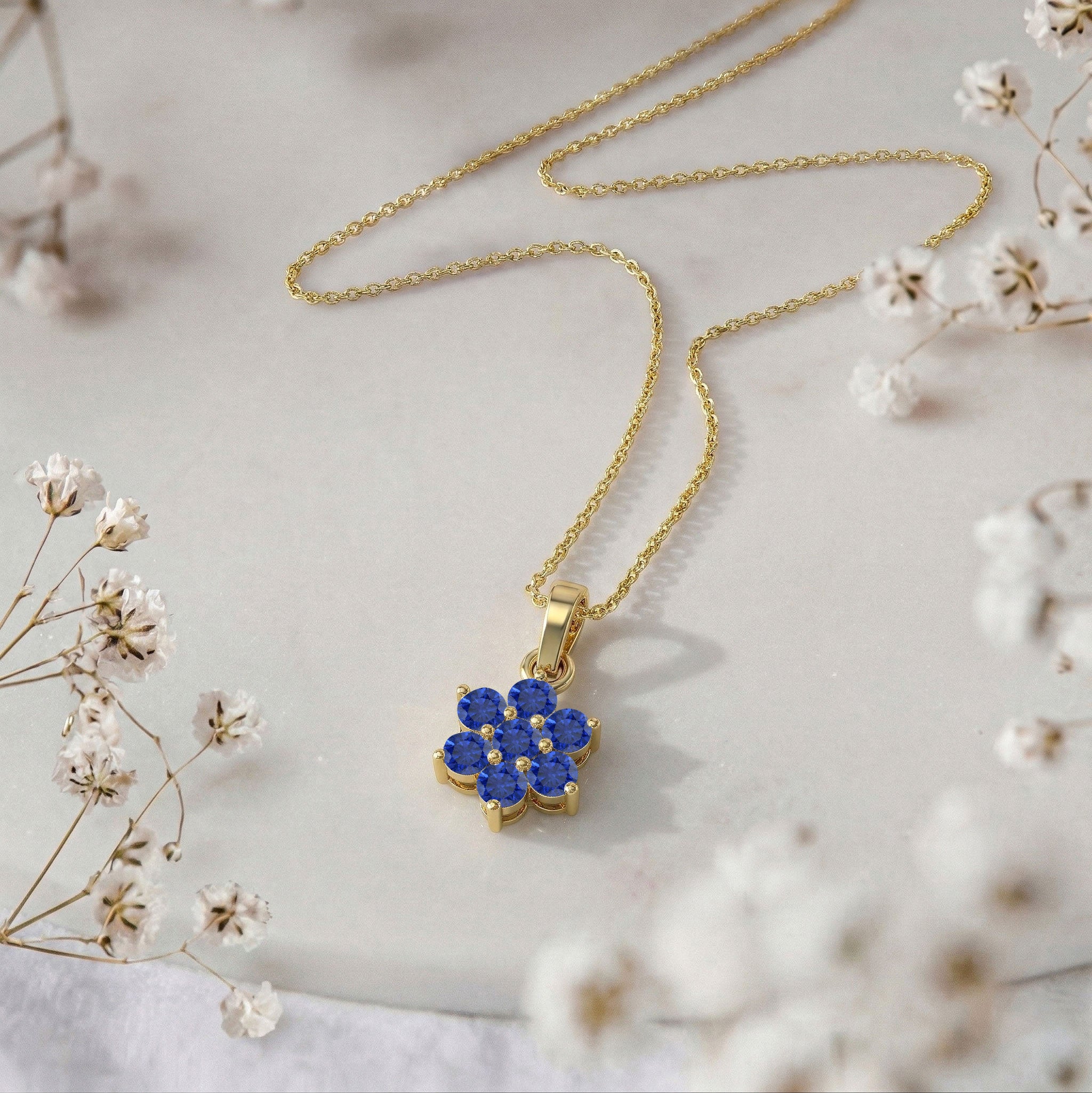 Fine jewelry Blue Sapphire flower pendant with seven round gemstone accents.