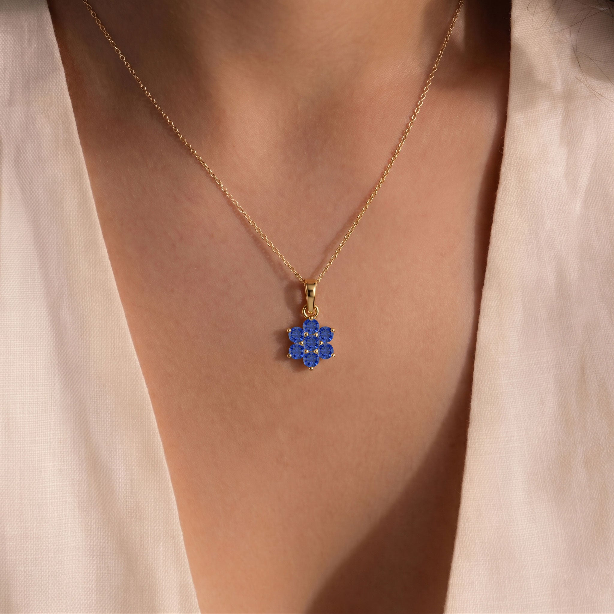 Luxury Blue Sapphire gemstone pendant necklace with elegant floral arrangement.