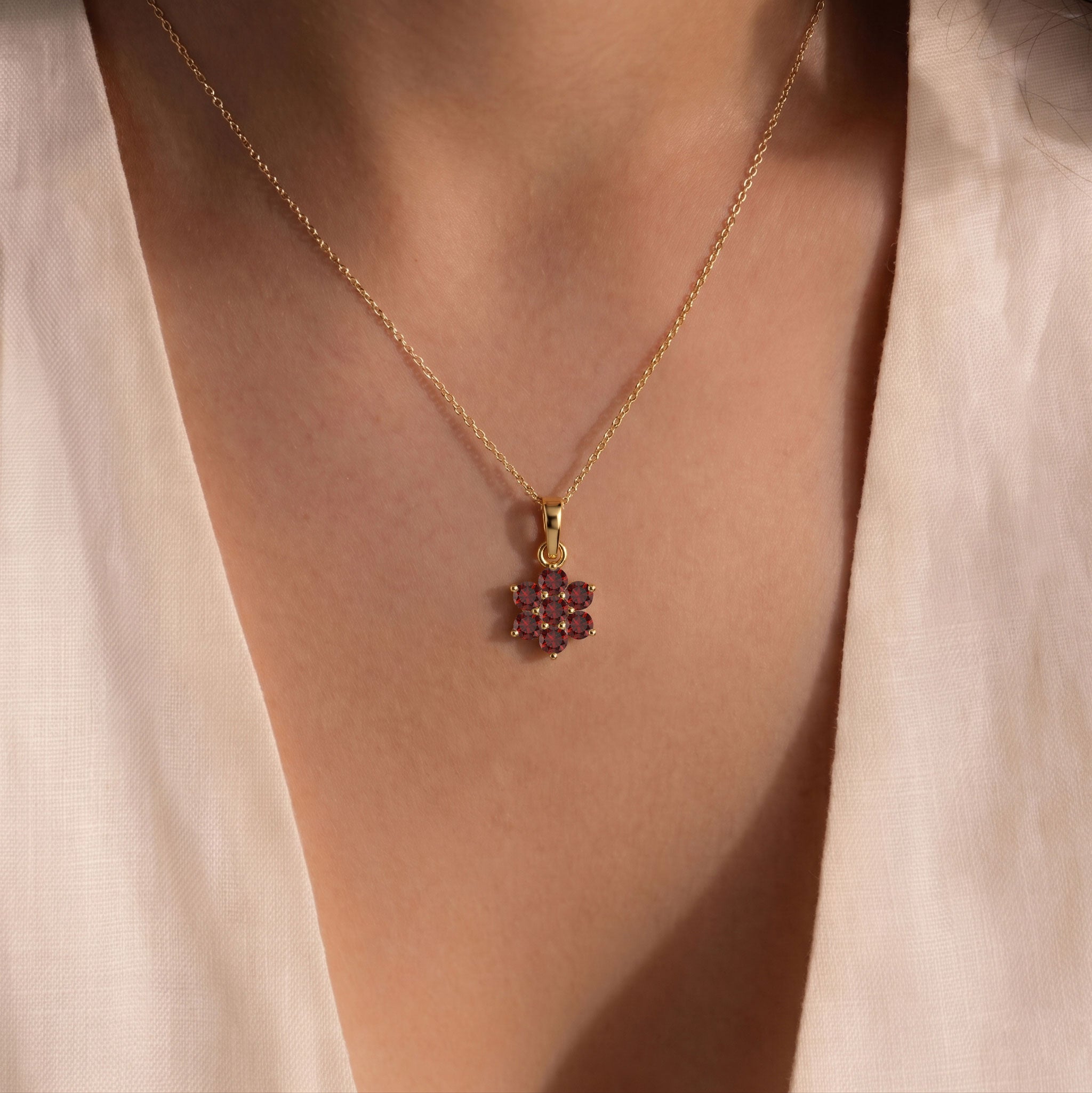 Floral gemstone necklace featuring seven round garnet gemstones