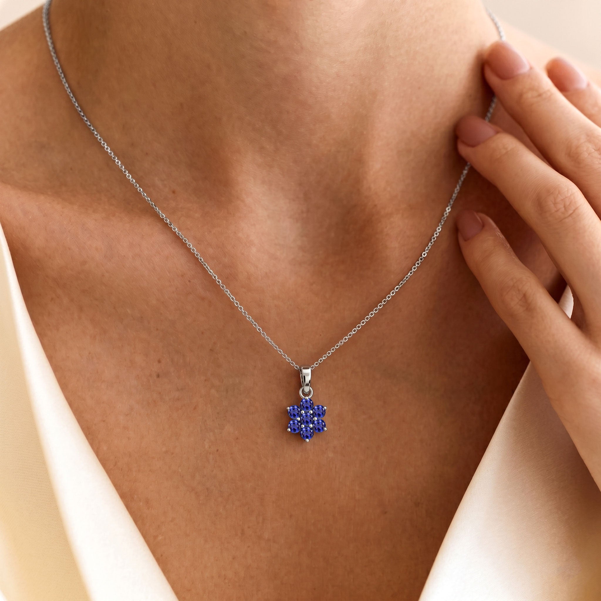 Floral pendant necklace featuring seven round tanzanite gemstones with blue tones