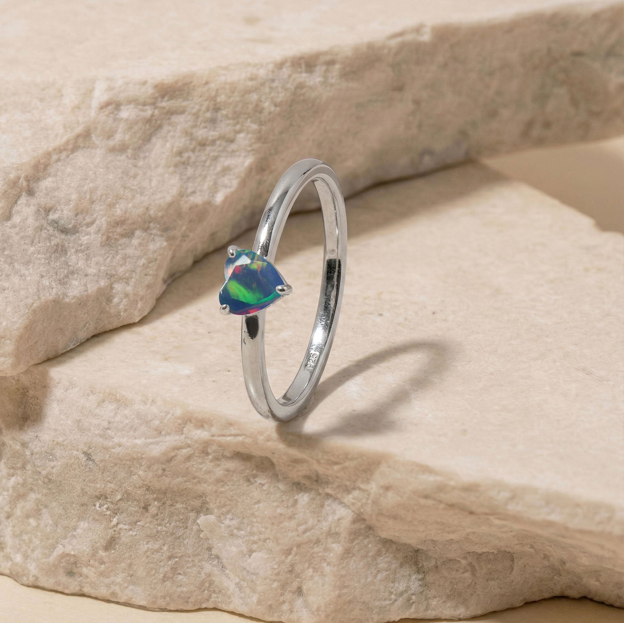 natural opal heart ring, solitaire gemstone accessory, colorful gemstone flashes, polished jewelry, romantic women's ring, minimalist jewelry style, handcrafted gemstone ring, elegant fashion accessory, fine jewelry gift, timeless craftsmanship, birthday ring, anniversary keepsake, promise jewelry, luxury design, gemstone beauty