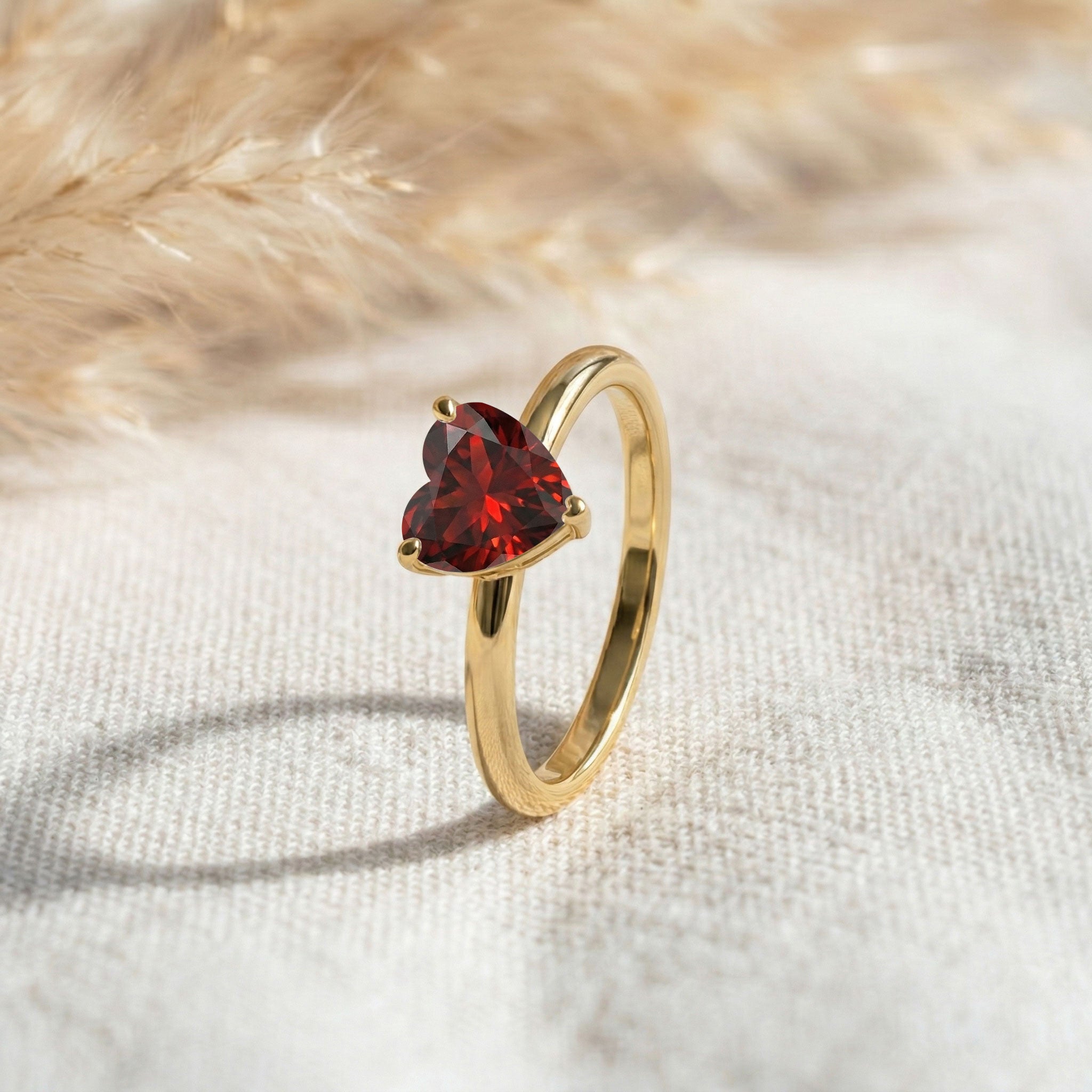 garnet solitaire jewelry, january birthstone accessory, polished band ring, heart shaped gemstone ring, handmade luxury jewelry, minimalist everyday style, elegant women's ring, artisan gemstone craftsmanship, romantic anniversary gift, dainty fashion jewelry, classic heart ring, refined gemstone accessory, fine jewelry collection, stackable ring style