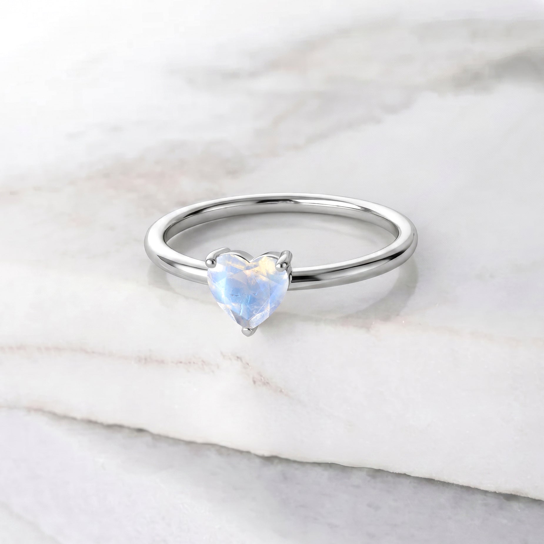 moonstone heart gemstone, solitaire jewelry design, handcrafted gemstone ring, elegant women's accessory, romantic jewelry gift, meaningful gemstone jewelry, june birthstone ring, artisan craftsmanship, classic solitaire style, fine gemstone accessory, everyday elegance, polished jewelry, feminine jewelry, timeless design, natural gemstone