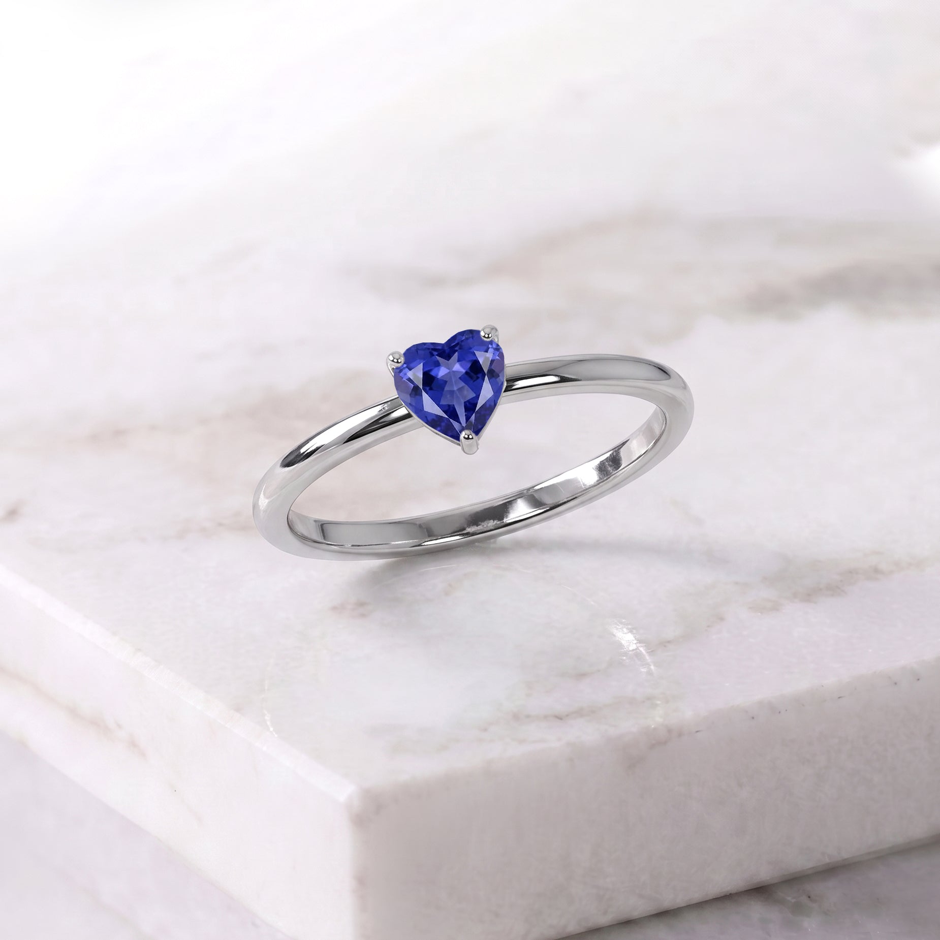 tanzanite heart gemstone, solitaire jewelry design, handcrafted women's ring, elegant gemstone accessory, classic promise jewelry, anniversary jewelry gift, birthday jewelry inspiration, artisan craftsmanship, premium gemstone, timeless elegance, romantic keepsake, polished jewelry, refined accessory, everyday style, gemstone beauty
