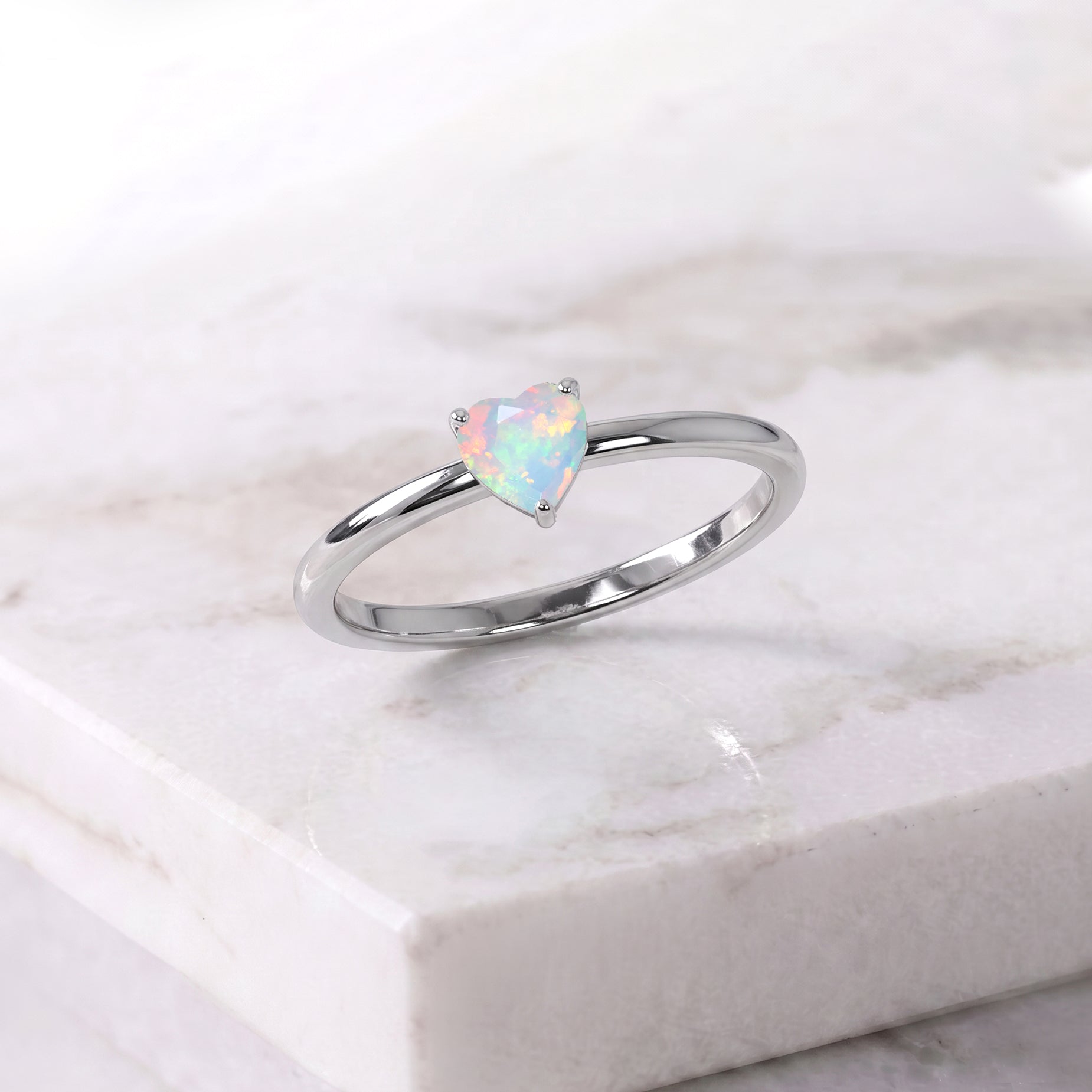 natural white opal jewelry, solitaire heart gemstone, october birthday ring, elegant fine jewelry, handcrafted artisan ring, women's gemstone accessory, promise jewelry, polished setting, minimalist ring style, classic gemstone design, anniversary present, romantic keepsake, delicate fashion jewelry, everyday elegance, timeless accessory