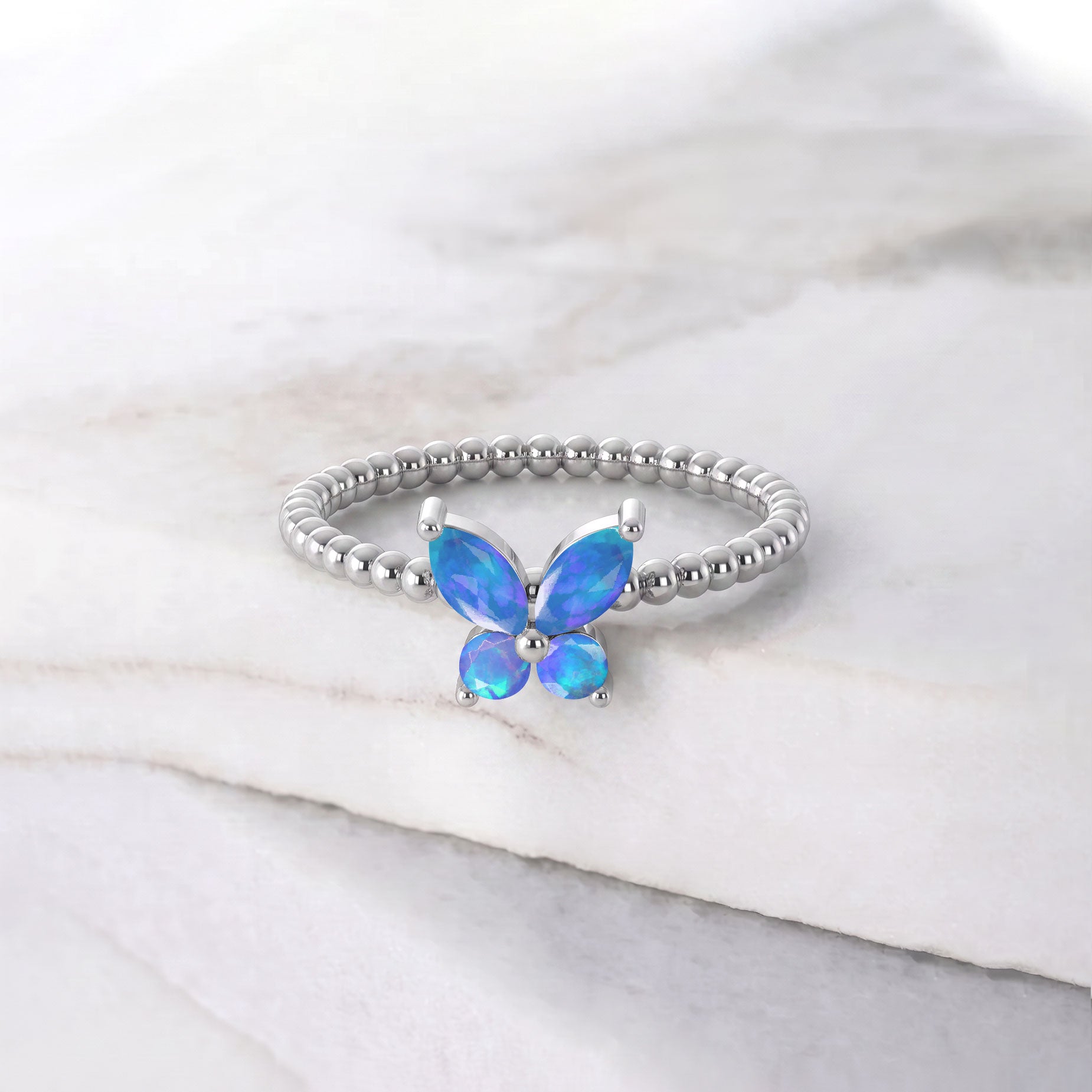 Elegant natural blue opal butterfly ring for women with vibrant blue opal gemstones, sculptural butterfly design, and refined sterling silver detailing