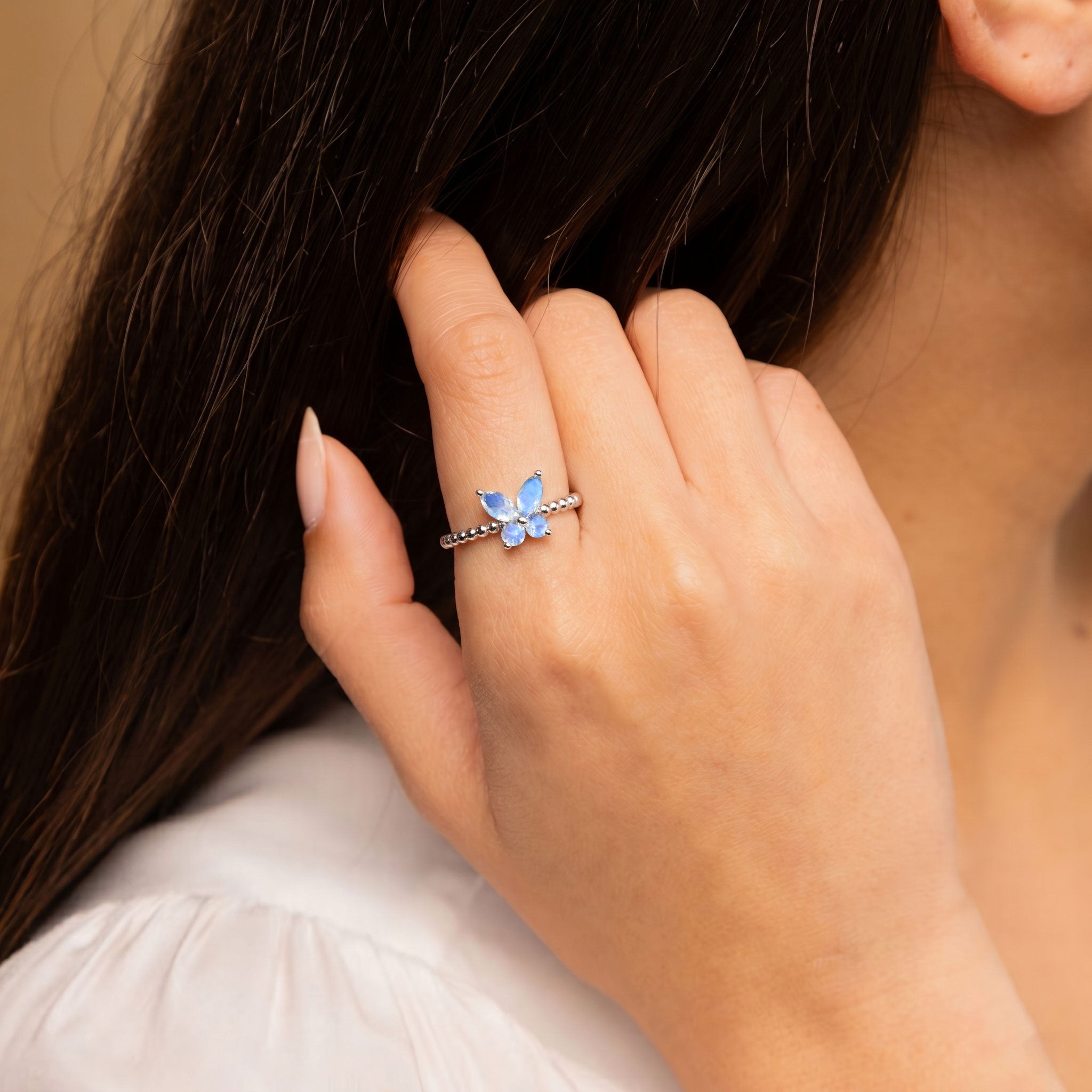 Unique natural moonstone ring with butterfly-inspired gemstone centerpiece, marquise cut stones, round accents and smooth polished metal band